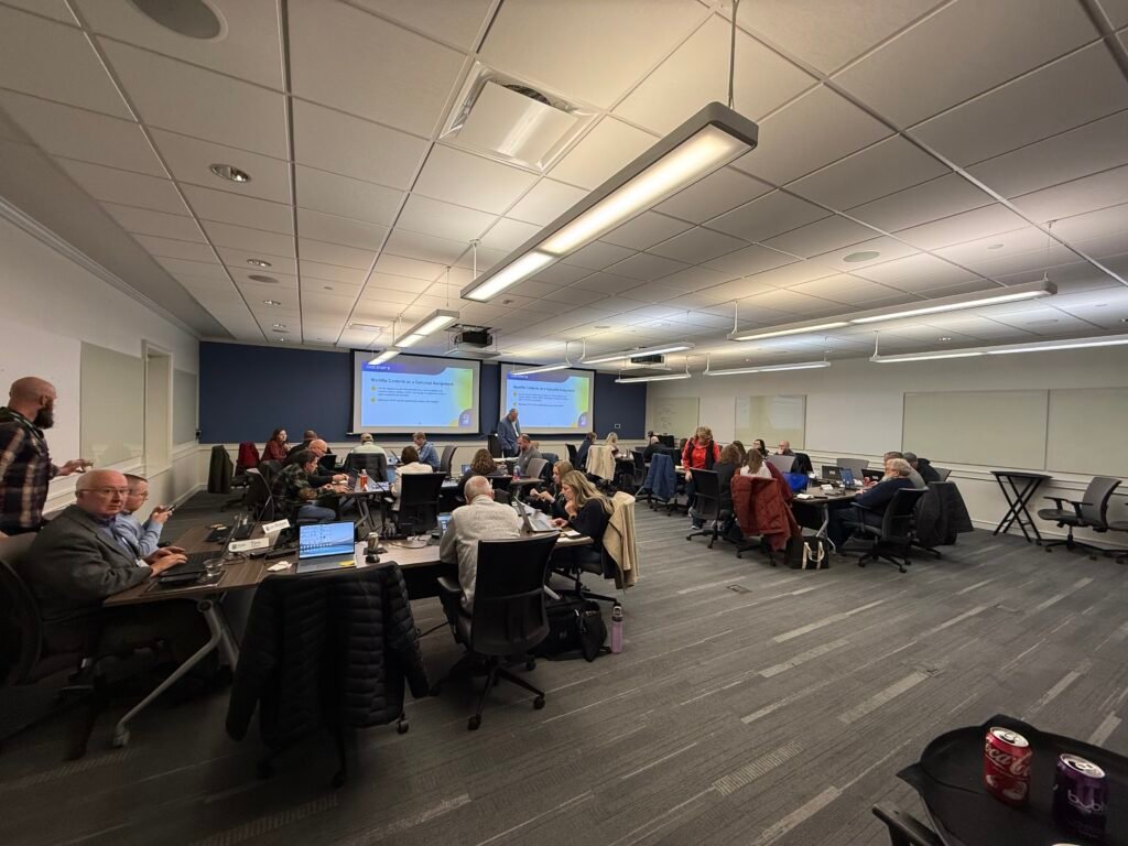 Appraisers attending a USPAP update course in a classroom setting with laptops open and the instructor presenting at the front.