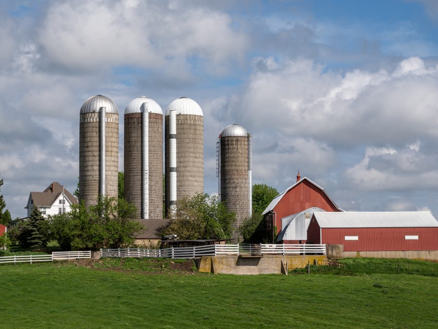 Dairy farm with old fashioned hip roof barn and stave silos. Wisconsin, USA.